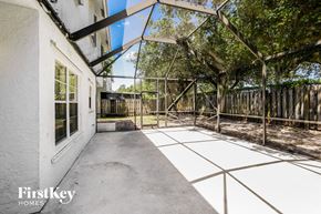 Sunrise house for rent - a large patio with a fence and trees on the side of a house