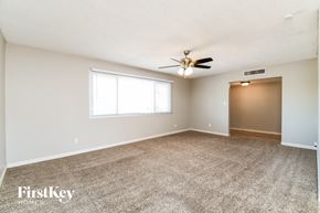 Tempe house for rent - A spacious room with a carpeted floor and a ceiling fan.