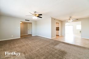 Tempe house for rent - A spacious room with a carpeted floor and a ceiling fan.