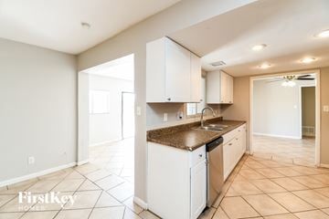 Tempe house for rent - A kitchen with white cabinets and a brown countertop.