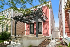 Saint Charles house for rent - A house with a red siding and a black pergola.