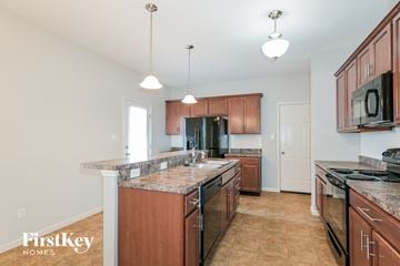 Saint Charles house for rent - A kitchen with brown cabinets and a granite countertop.
