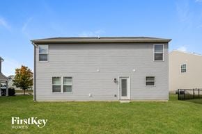 Indianapolis house for rent - the backyard of a home with a white house and a grassy yard