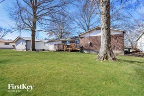 Florissant house for rent - A house with a lawn and trees in front of it.