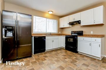 Florissant house for rent - A kitchen with a tile floor and a refrigerator.