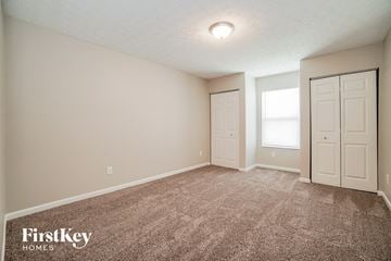 Columbus house for rent - the spacious living room with carpet and a door to the bedroom
