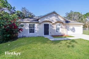 Palm Bay house for rent - front view of a white house with a yard and grass