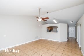 Palm Bay house for rent - an empty living room with a ceiling fan and a tiled floor