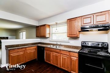 Indianapolis house for rent - A kitchen with wooden cabinets and a black stove top oven.