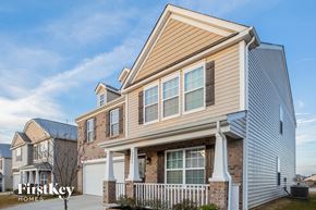 Concord house for rent - A house with a brown siding and a white fence is shown.