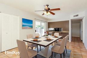 Phoenix house for rent - A dining room with a table set for two and a painting of a beach scene on the wall.