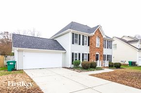 High Point house for rent - A two-story house with a brick facade and a white garage door.
