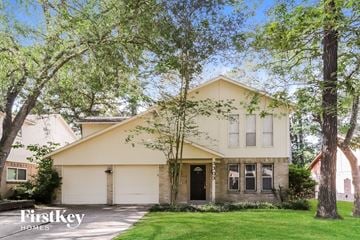 Kingwood house for rent - a house with a lawn and trees in front of it