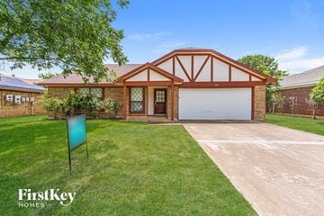 Fort Worth house for rent - a house with a driveway and lawn and a garage door