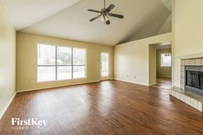 Fort Worth house for rent - an empty living room with a fireplace and a ceiling fan