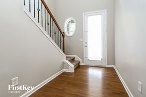 Cumming house for rent - a foyer with a staircase and a door to a room with wood floors