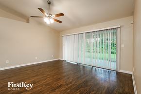 Lehigh Acres house for rent - the living room of an empty house with a large window and a ceiling fan