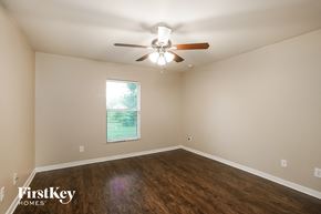 Lehigh Acres house for rent - a living room with a ceiling fan and wood floors