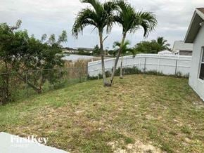 Miami Gardens house for rent - a backyard with two palm trees and a fence