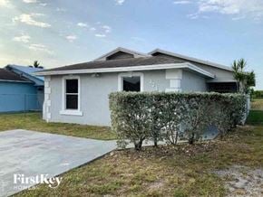 Miami Gardens house for rent - a small white house with a yard and a garage