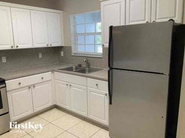 Miami Gardens house for rent - a white kitchen with a refrigerator and a sink