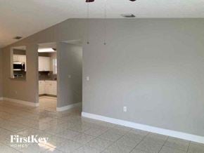 Miami Gardens house for rent - an empty living room and kitchen with a tile floor