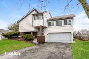 Hazel Crest house for rent - a white house with a white garage door on a driveway