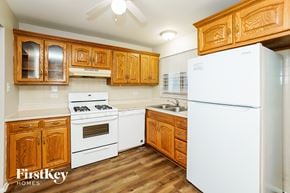 Hazel Crest house for rent - a kitchen with white appliances and wooden cabinets