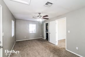 Tempe house for rent - A spacious room with a ceiling fan and carpeted floor.