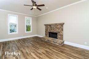 Dacula house for rent - A room with a stone fireplace and wooden flooring.