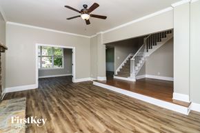 Dacula house for rent - A spacious room with wooden floors and a staircase leading to another level.