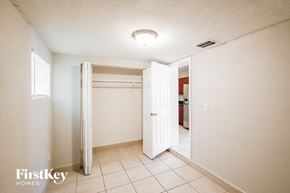Miami Gardens house for rent - A white bedroom with a large open closet door.