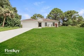 North Port house for rent - a white house with a lawn and a driveway