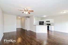 North Port house for rent - an empty living room with a ceiling fan and a kitchen