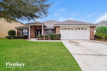 Orange Park house for rent - a home with a white garage door and a lawn