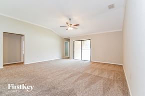 Orange Park house for rent - a spacious living room with carpet and a ceiling fan