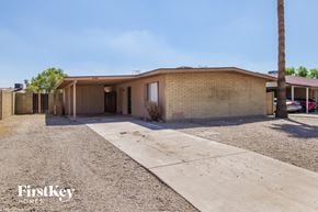 Phoenix house for rent - a small brick house with a driveway and a palm tree