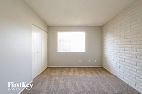 Phoenix house for rent - a bedroom with white brick walls and carpet and a window