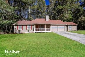Powder Springs house for rent - A house with a red roof and a chimney is surrounded by trees.
