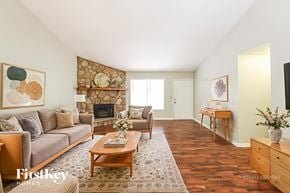 Powder Springs house for rent - A living room with a stone fireplace and a wooden coffee table.