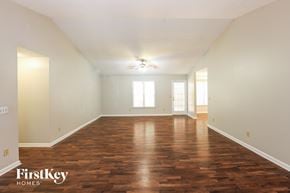 Powder Springs house for rent - A spacious room with wooden floors and a ceiling fan.