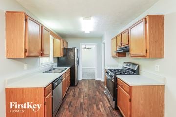 Powder Springs house for rent - A kitchen with wooden cabinets and black appliances.