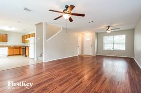 Dallas house for rent - A spacious room with wooden floors and a ceiling fan.