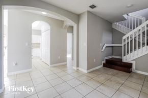 Homestead house for rent - a large entryway with a staircase and tiled flooring