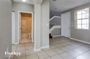 Homestead house for rent - a bathroom with a white door and a staircase in a house