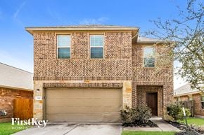 Houston house for rent - A brick house with a garage door and a sign that says Firstkey Homes.