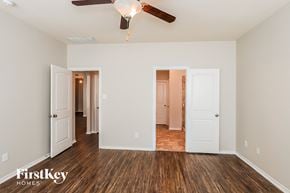 Houston house for rent - A room with a ceiling fan and wooden floors.