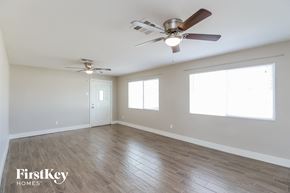 Phoenix house for rent - A spacious room with a ceiling fan and two windows.