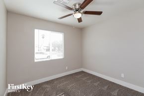 Phoenix house for rent - A room with a ceiling fan and a window showing a view of a building outside.