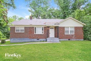 Memphis house for rent - a small brick house with a white front door and a lawn